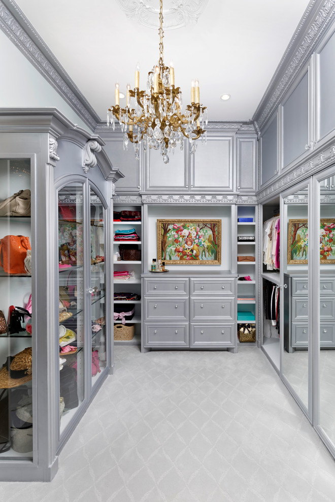 This is an example of an expansive traditional women's walk-in wardrobe in Houston with recessed-panel cabinets, grey cabinets and carpet.