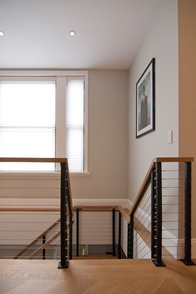 Design ideas for a large contemporary wood u-shaped staircase in New York with open risers and cable railing.