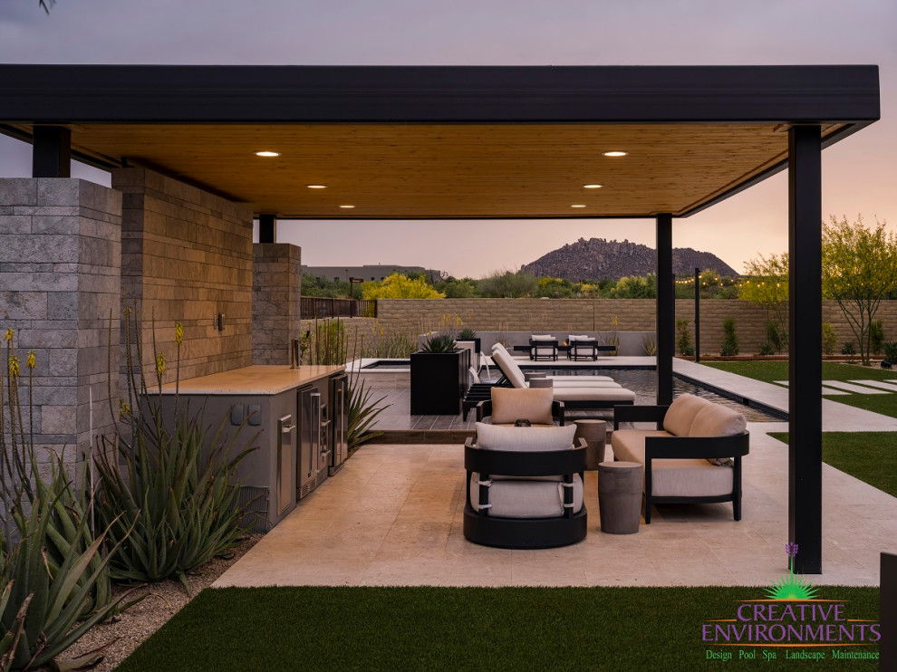 Large modern backyard partial sun formal garden in Phoenix with concrete pavers and a metal fence for summer.