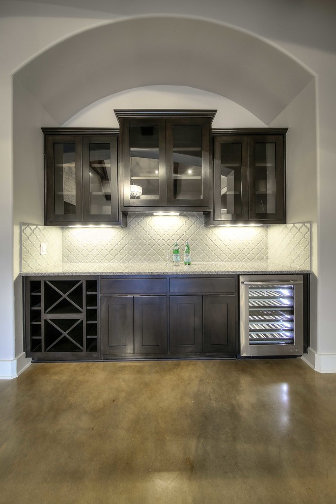 Mid-sized transitional single-wall seated home bar in Austin with glass-front cabinets, dark wood cabinets, granite benchtops and white splashback.