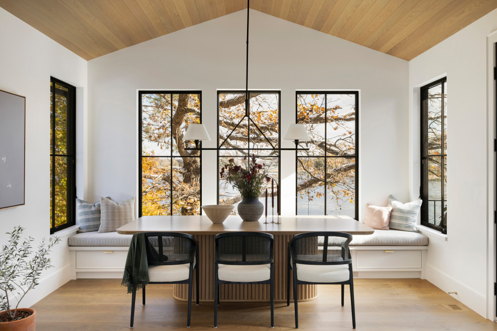 Example of a mid-sized transitional open concept medium tone wood floor, brown floor and vaulted ceiling living room design in Minneapolis with white walls, a standard fireplace and a stone fireplace