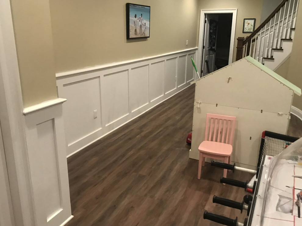 This is an example of a large transitional walk-out basement in Newark with beige walls, dark hardwood floors, no fireplace and brown floor.