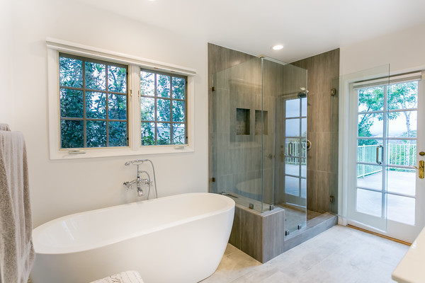 Large modern bathroom in Los Angeles with a freestanding tub, shaker cabinets, white cabinets, a two-piece toilet, white tile, white walls, ceramic floors, an undermount sink and with a sauna.