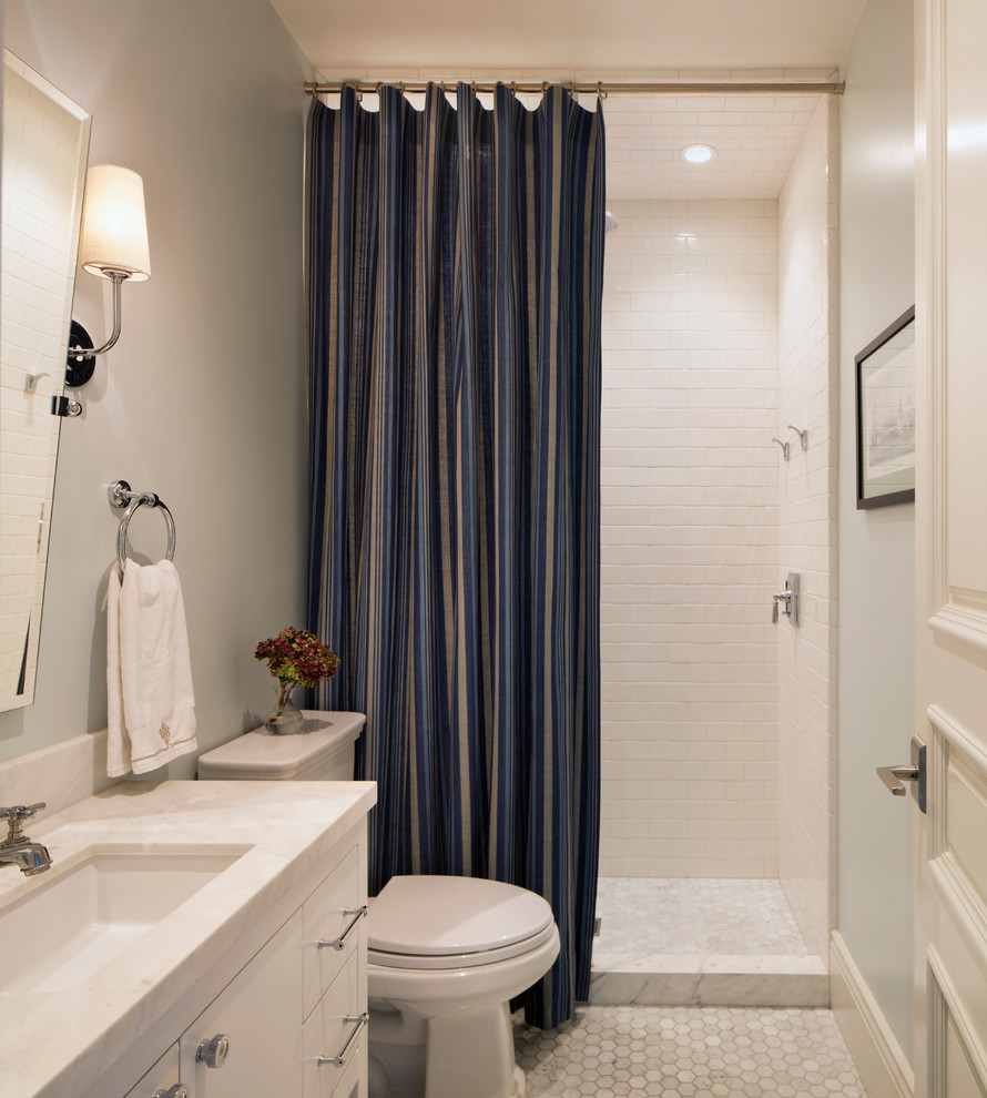 Immagine di una stanza da bagno chic di medie dimensioni con ante bianche, WC monopezzo, pareti grigie, pavimento in gres porcellanato, lavabo sottopiano, top in marmo, pavimento bianco e doccia con tenda