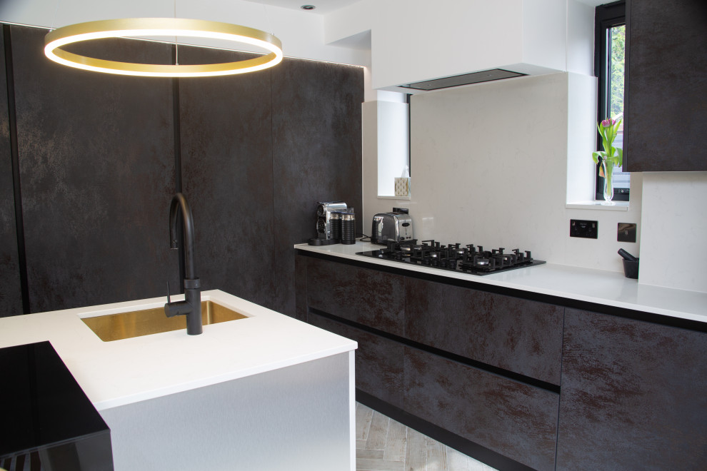 Mid-sized contemporary l-shaped eat-in kitchen in Essex with a single-bowl sink, glass benchtops and black benchtop.