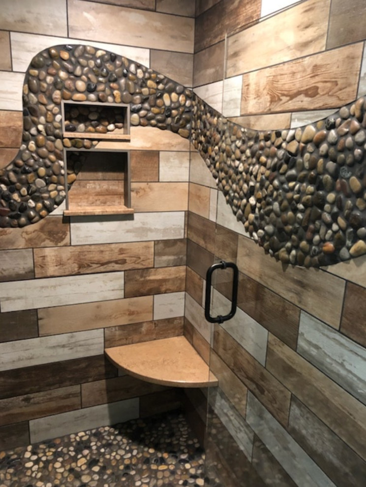 Design ideas for a mid-sized traditional master bathroom in Other with a corner shower, a two-piece toilet, beige tile, brown tile, gray tile, porcelain tile, multi-coloured walls, pebble tile floors, multi-coloured floor and a hinged shower door.