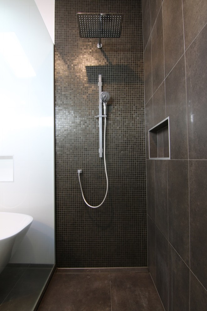 This is an example of a large modern wet room bathroom in Auckland with black tile, mosaic tile and an open shower.