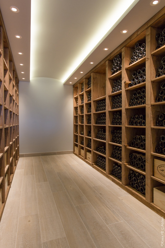 Design ideas for a large industrial wine cellar in Paris with ceramic floors, storage racks and brown floor.