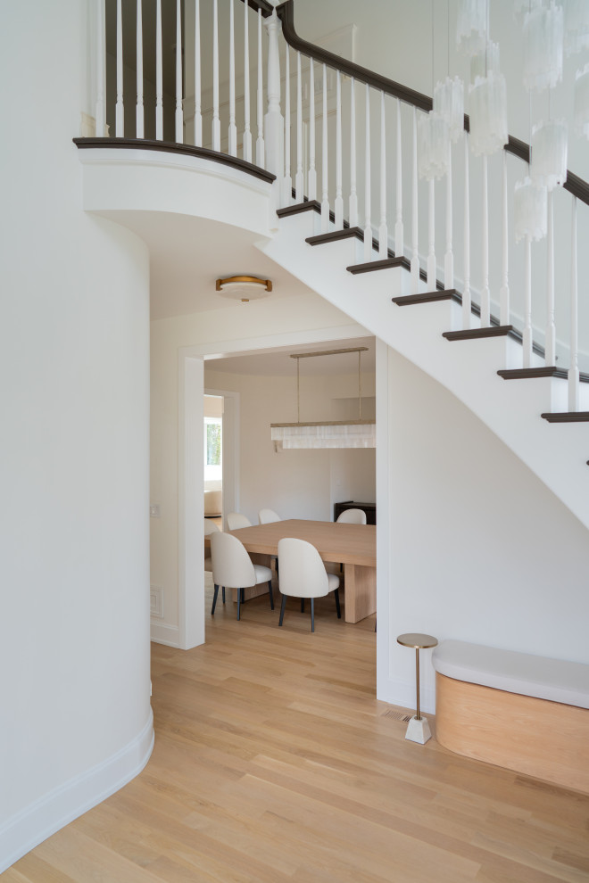 Elegant Home Interior Entrance With Curved Staircase and Black Double Doors