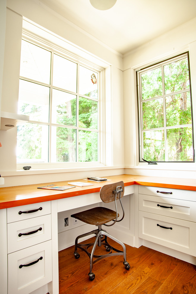 This is an example of a mid-sized traditional u-shaped eat-in kitchen in Vancouver with an undermount sink, shaker cabinets, white cabinets, blue splashback, ceramic splashback, stainless steel appliances, medium hardwood floors, with island, brown floor, wood benchtops and orange benchtop.