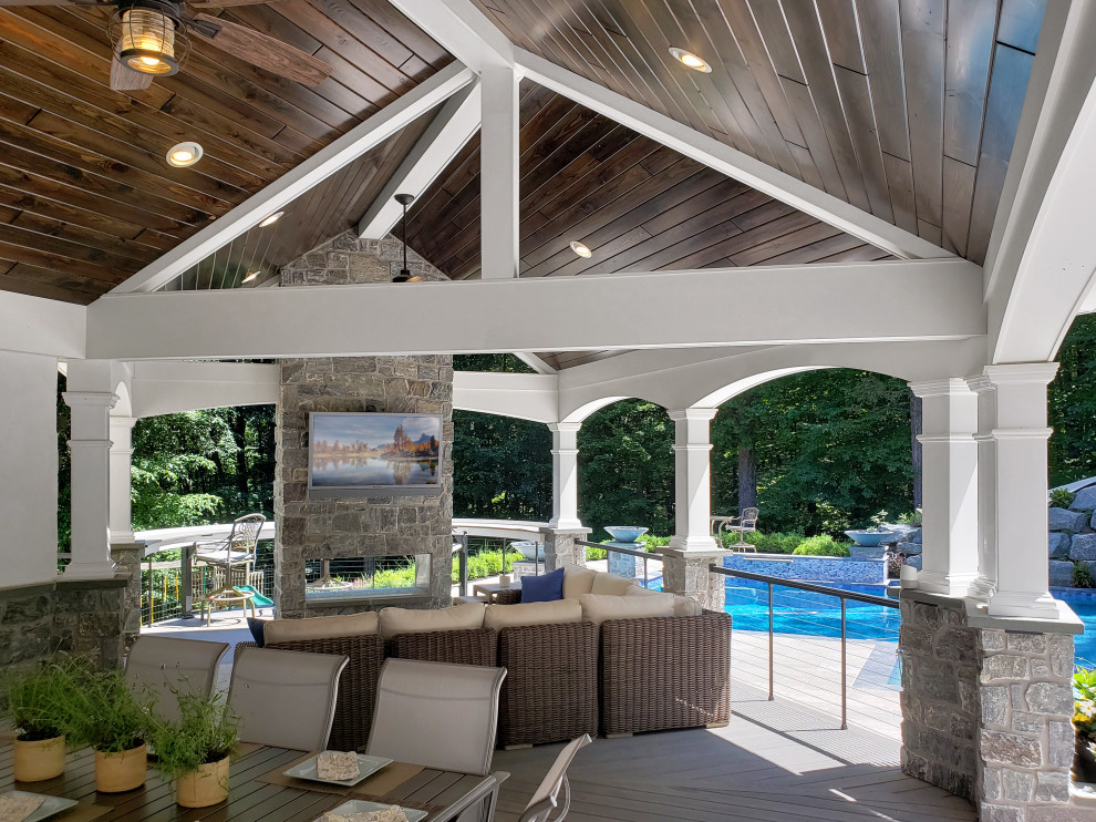 Transitional metal railing back porch photo with a fireplace