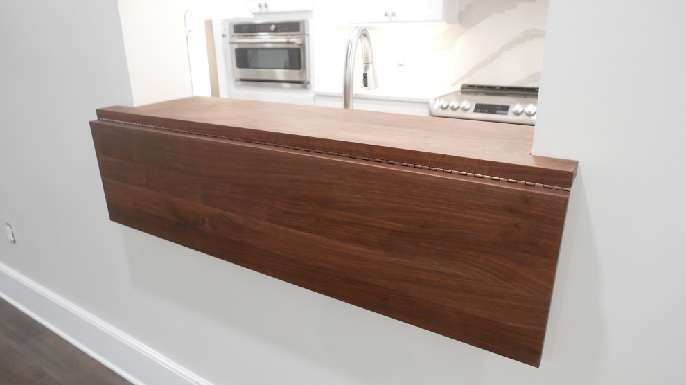 Mid-sized transitional galley laminate floor and multicolored floor eat-in kitchen photo with a farmhouse sink, shaker cabinets, white cabinets, quartz countertops, white backsplash, quartz backsplash, stainless steel appliances and white countertops