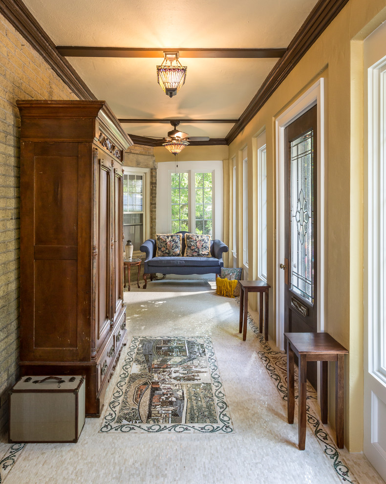 This is an example of a mid-sized traditional entry hall in Milwaukee with yellow walls, a single front door and a dark wood front door.