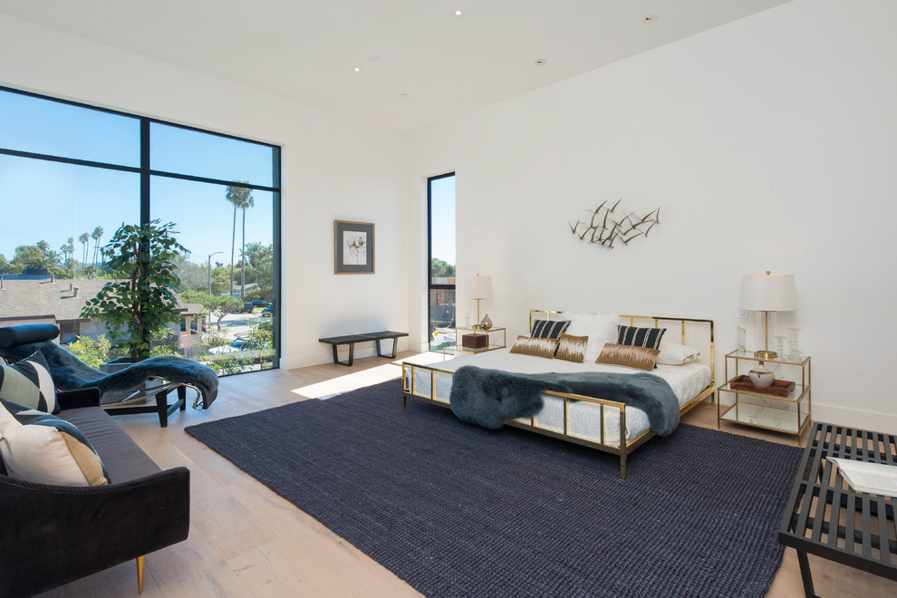 Contemporary bedroom in Los Angeles with white walls and light hardwood floors.