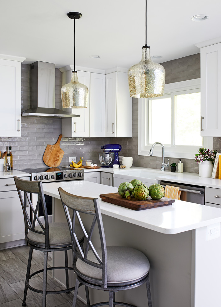 Inspiration for a mid-sized transitional l-shaped separate kitchen in DC Metro with a farmhouse sink, white cabinets, quartzite benchtops, grey splashback, subway tile splashback, stainless steel appliances, with island, white benchtop, shaker cabinets, medium hardwood floors and grey floor.