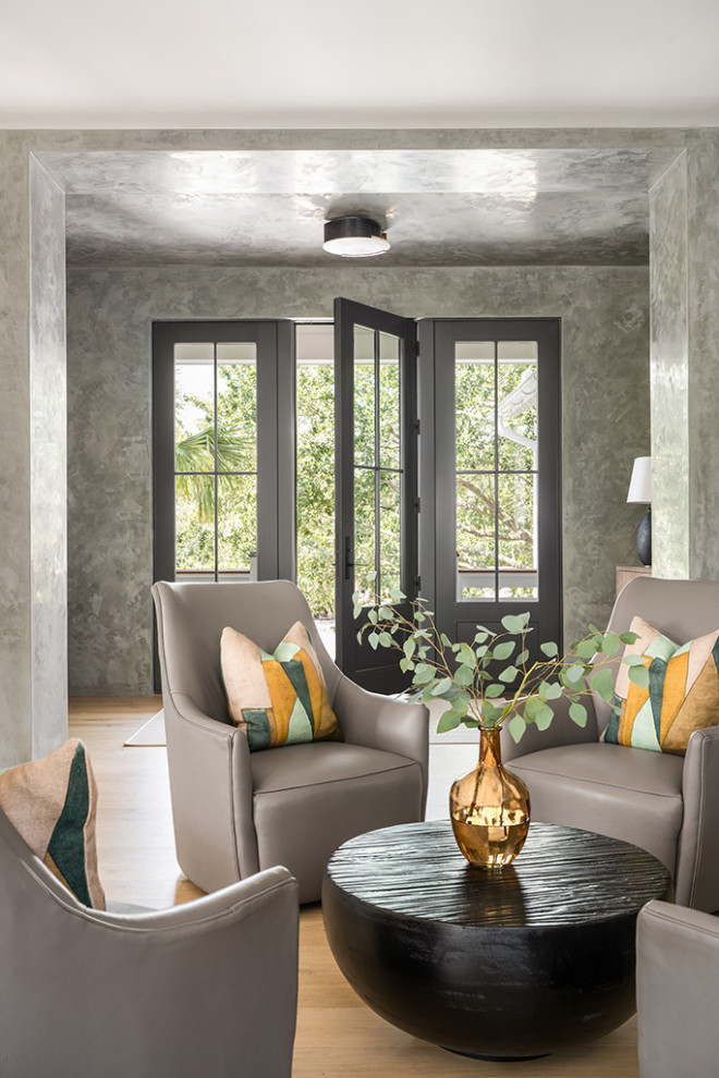 Esempio di un soggiorno design aperto con pareti grigie e parquet chiaro