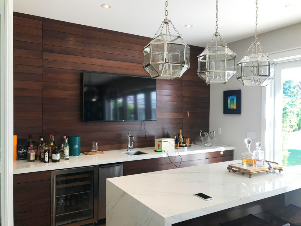 Inspiration for a large modern galley seated home bar in Miami with a drop-in sink, flat-panel cabinets, medium wood cabinets, quartz benchtops, brown splashback, shiplap splashback, medium hardwood floors, brown floor and white benchtop.