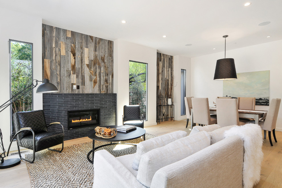 Transitional open concept living room in San Francisco with white walls, medium hardwood floors, a standard fireplace and a tile fireplace surround.
