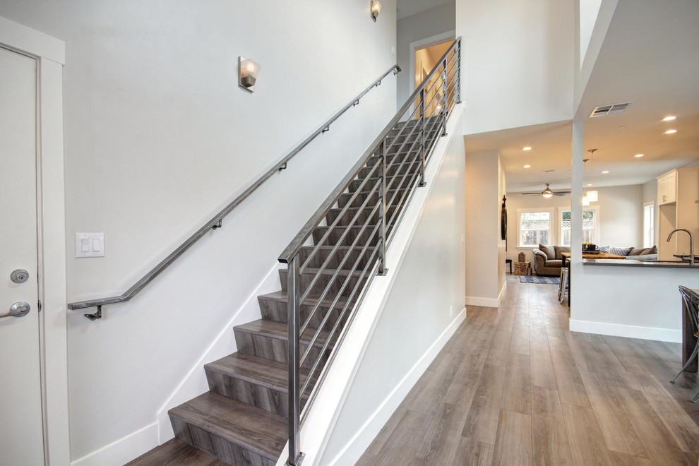 This is an example of a small contemporary wood straight staircase in Sacramento with wood risers.