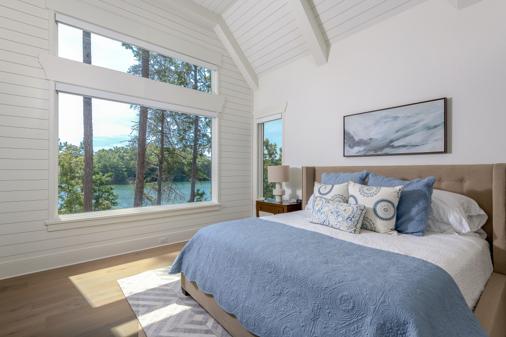 Transitional bedroom in Other with white walls, medium hardwood floors, brown floor, exposed beam, timber, vaulted and planked wall panelling.