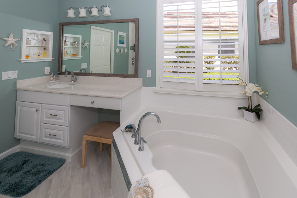 Стильный дизайн: большая главная ванная комната в морском стиле с фасадами с выступающей филенкой, белыми фасадами, угловой ванной, душем без бортиков, унитазом-моноблоком, белой плиткой, плиткой кабанчик, синими стенами, полом из винила, врезной раковиной, столешницей из искусственного кварца, серым полом, открытым душем, белой столешницей, сиденьем для душа, тумбой под две раковины и встроенной тумбой - последний тренд