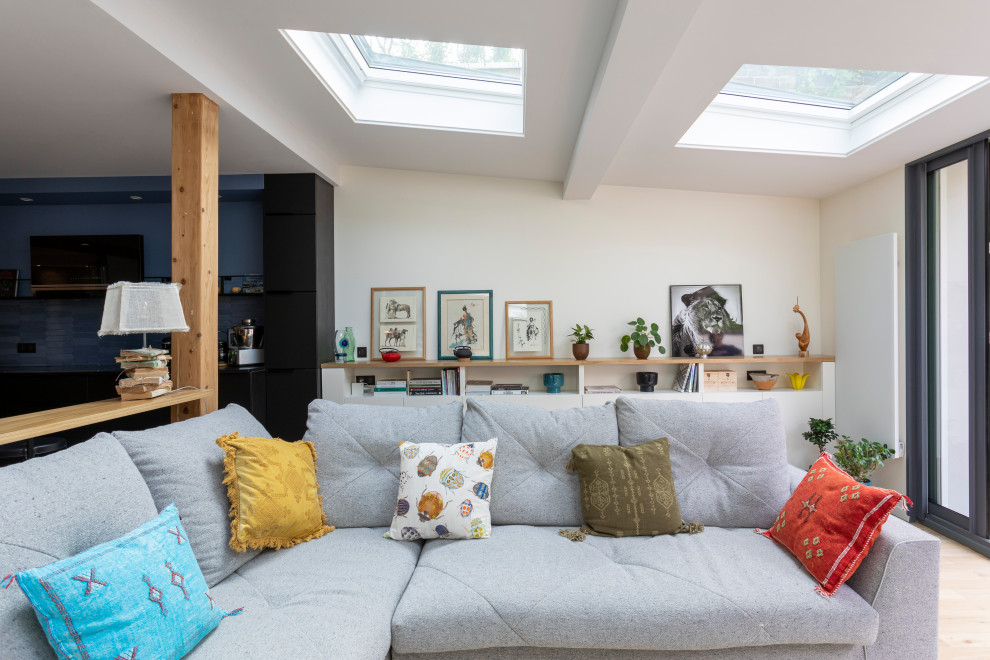 Esempio di un grande soggiorno aperto con pareti bianche, parquet chiaro, TV nascosta e pavimento marrone