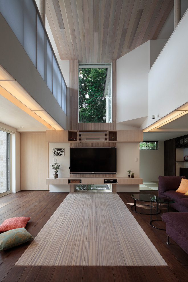 Large asian formal open concept living room in Tokyo with bamboo floors, no fireplace, a wall-mounted tv, white floor and white walls.