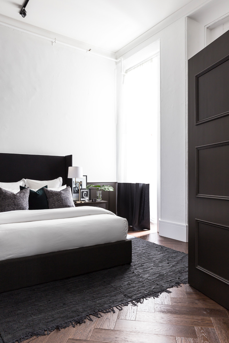Small contemporary master bedroom in Sydney with white walls, dark hardwood floors and brown floor.