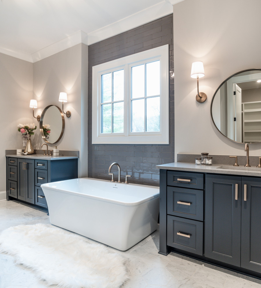 Design ideas for a transitional master bathroom with shaker cabinets, blue cabinets, a freestanding tub, gray tile, subway tile, grey walls, an undermount sink, engineered quartz benchtops, grey floor, grey benchtops, a double vanity and a built-in vanity.