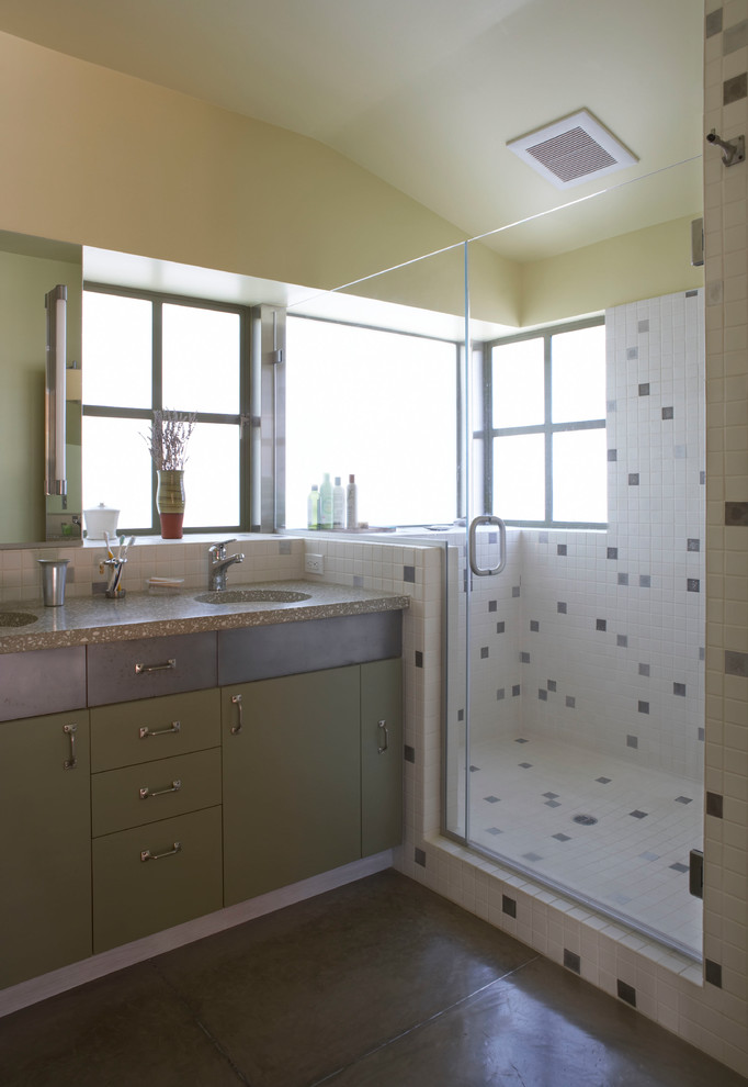 This is an example of a mid-sized eclectic master bathroom in San Francisco with a double shower, multi-coloured tile, an undermount sink, a hinged shower door, flat-panel cabinets, green cabinets, metal tile, concrete floors, concrete benchtops, beige walls and brown floor.