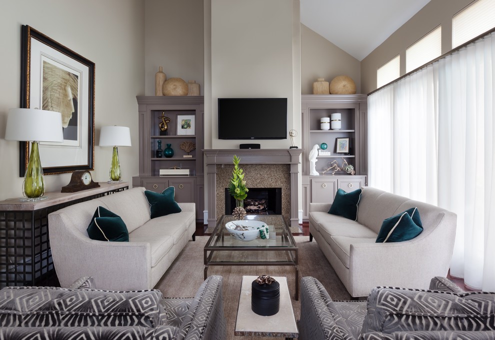 This is an example of a mid-sized transitional enclosed living room in Minneapolis with beige walls, a standard fireplace, a wall-mounted tv, medium hardwood floors, a stone fireplace surround and brown floor.