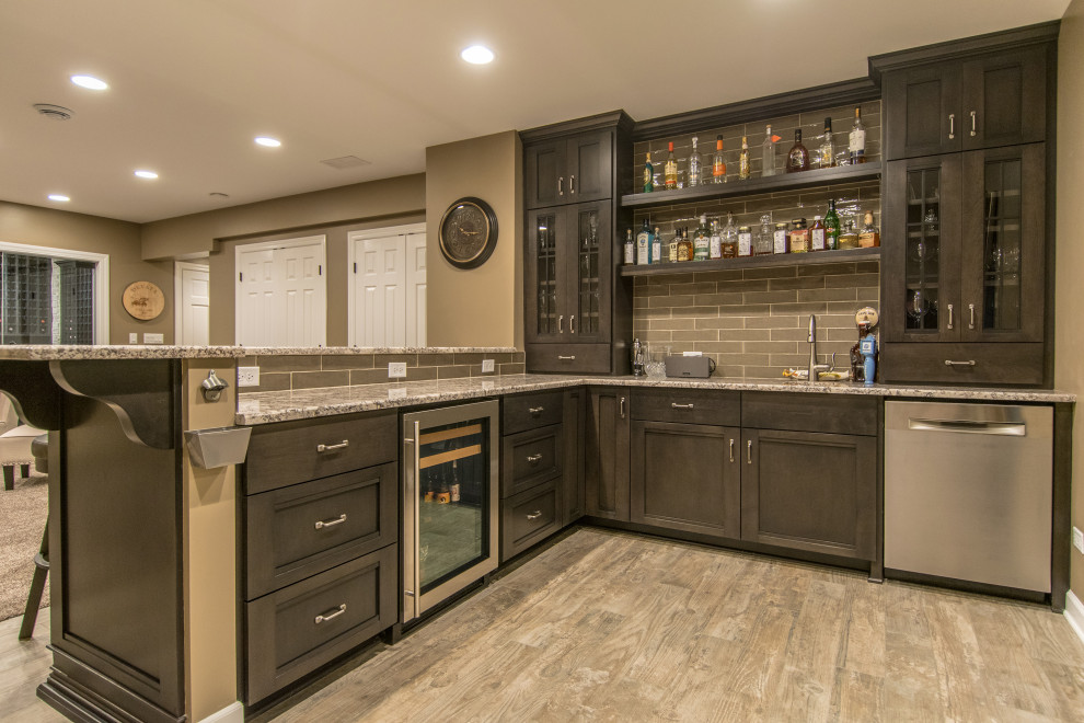 Photo of a large modern l-shaped breakfast bar in Chicago with a submerged sink, marble worktops, grey splashback, stone tiled splashback, laminate floors, beige floors and grey worktops.