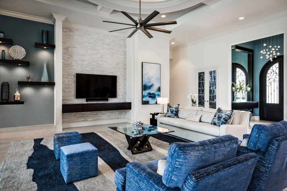 This is an example of a mid-sized transitional open concept family room in Miami with multi-coloured walls, porcelain floors, a wall-mounted tv and no fireplace.