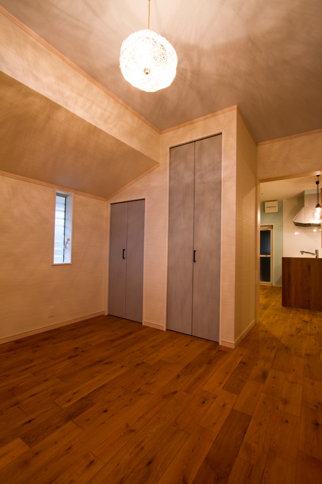 Immagine di una camera matrimoniale stile marinaro con pavimento in legno massello medio, pavimento beige, soffitto in carta da parati e carta da parati
