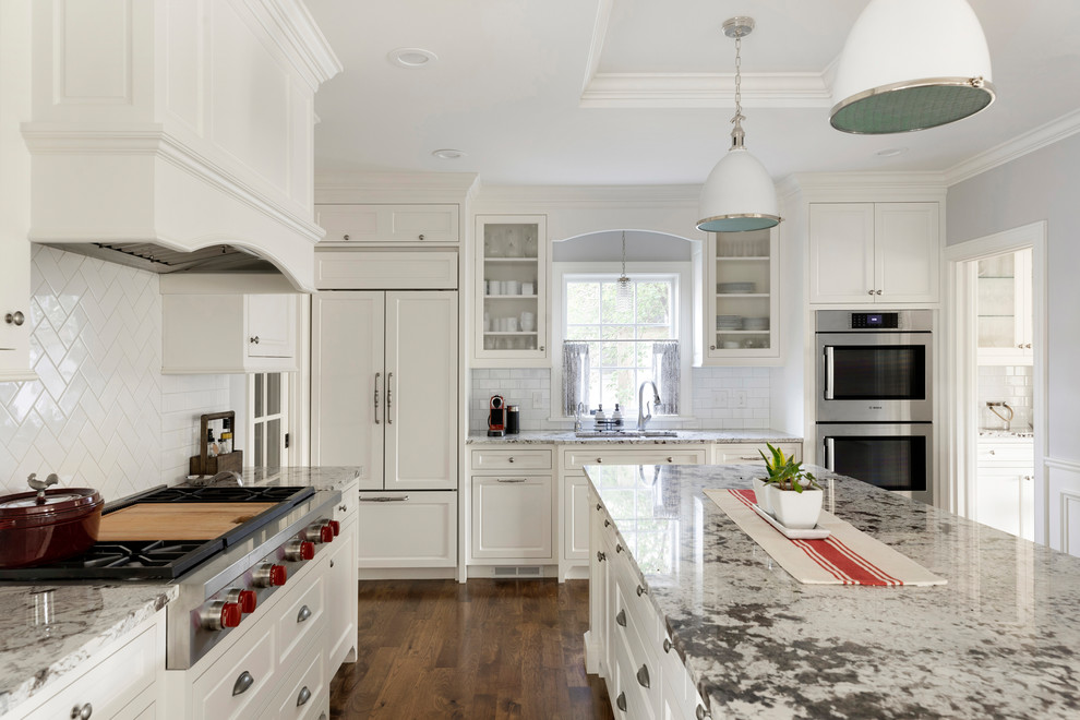Inspiration for a traditional l-shaped separate kitchen in Minneapolis with an undermount sink, recessed-panel cabinets, white cabinets, white splashback, porcelain splashback, panelled appliances, dark hardwood floors, with island, brown floor and grey benchtop.