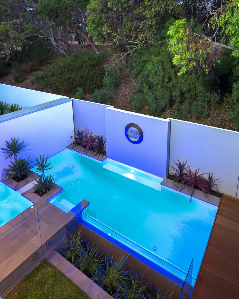 Contemporary backyard custom-shaped lap pool in Adelaide with decking and a hot tub.