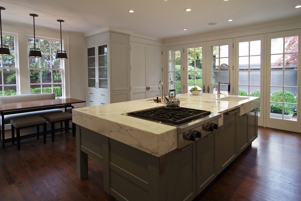Inspiration for a large contemporary single-wall eat-in kitchen in Atlanta with a double-bowl sink, flat-panel cabinets, white cabinets, marble benchtops, stainless steel appliances, medium hardwood floors, with island and brown floor.