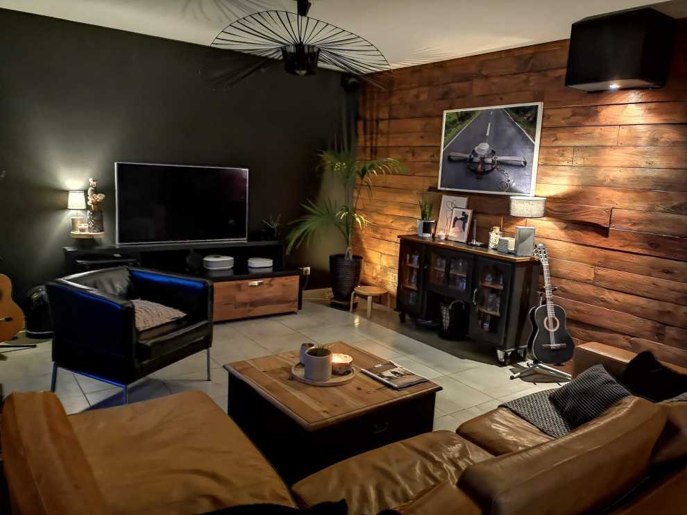 Mittelgroßes, Offenes Industrial Wohnzimmer mit schwarzer Wandfarbe, TV-Wand, grauem Boden und Holzwänden in Sonstige