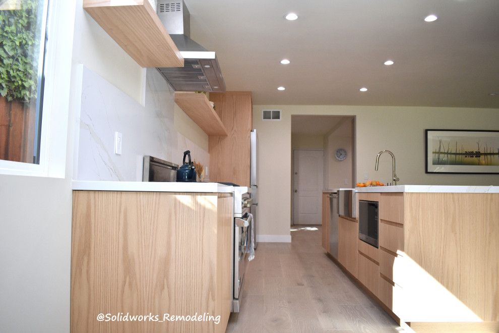 Zweizeilige Retro Wohnküche mit Landhausspüle, flächenbündigen Schrankfronten und Kücheninsel in Los Angeles