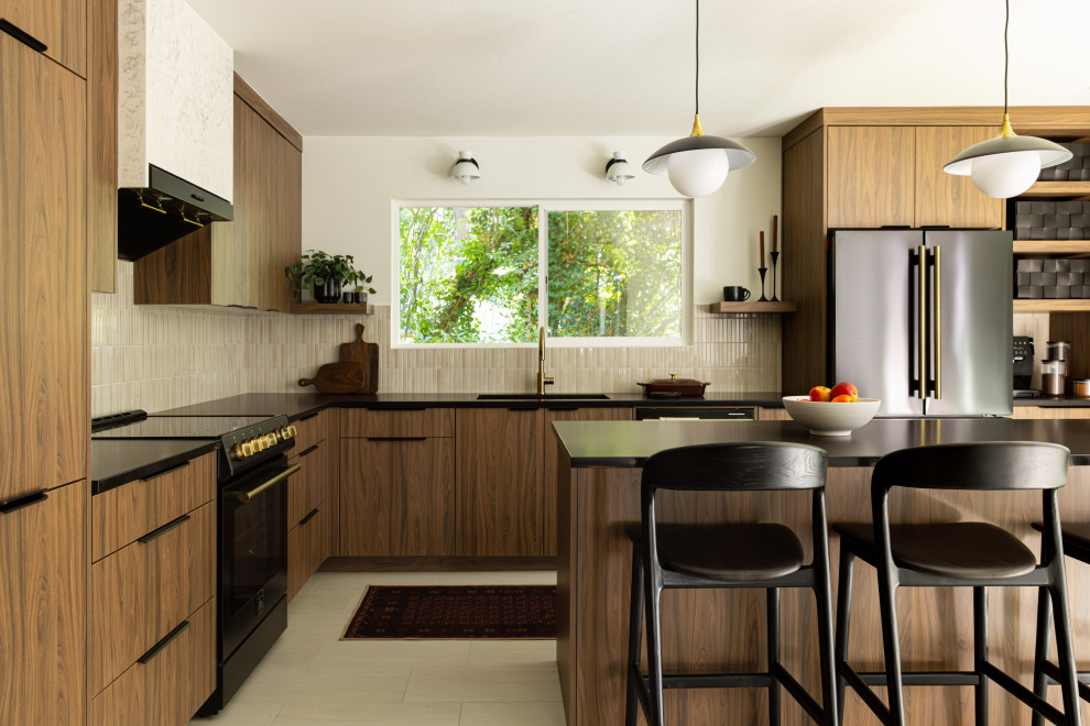Inspiration for a mid-century modern l-shaped beige floor kitchen remodel in Portland with flat-panel cabinets, quartzite countertops, an island, black countertops, an undermount sink, medium tone wood cabinets, beige backsplash, mosaic tile backsplash and stainless steel appliances