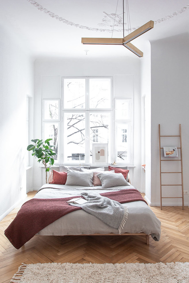 Contemporary guest bedroom in Berlin with white walls, medium hardwood floors and beige floor.