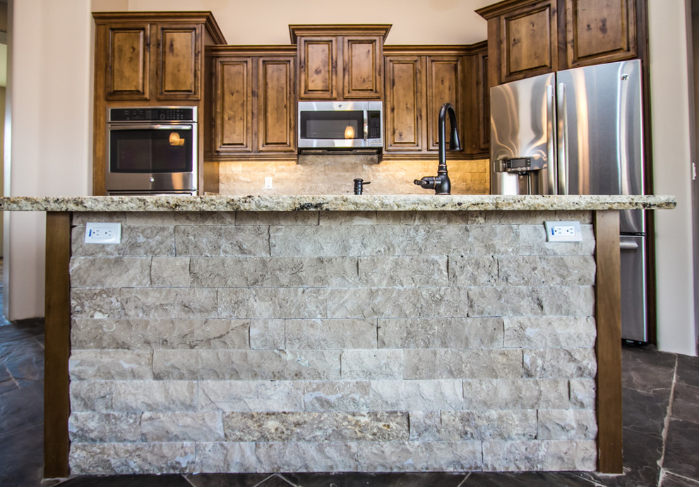 Inspiration for a large rustic u-shaped slate floor eat-in kitchen remodel in Phoenix with an undermount sink, raised-panel cabinets, brown cabinets, granite countertops, beige backsplash, stone tile backsplash, stainless steel appliances and two islands