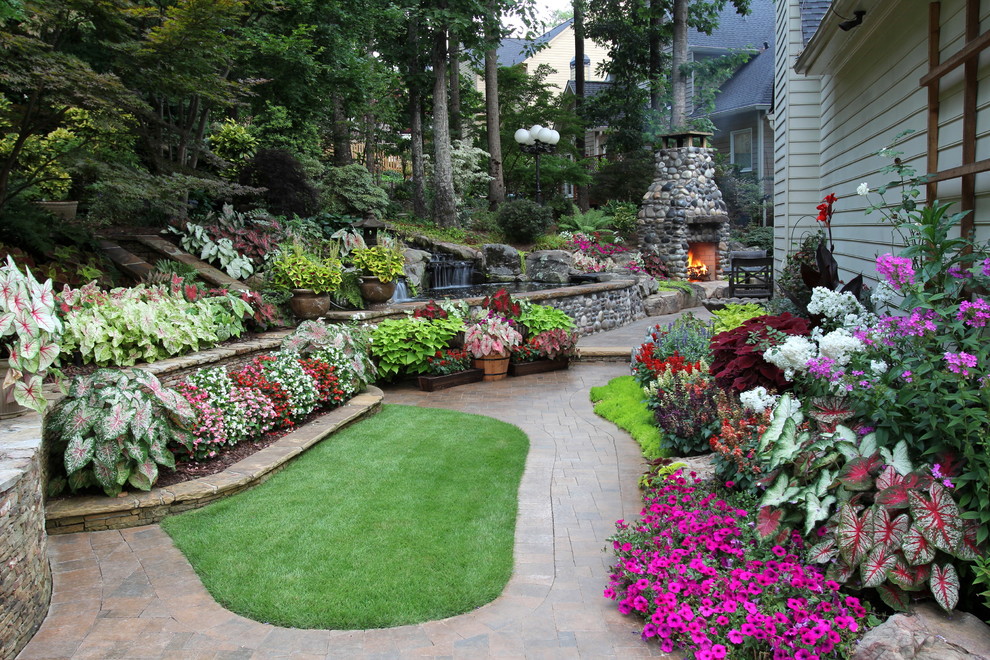 This is an example of a traditional backyard garden in Atlanta with brick pavers.