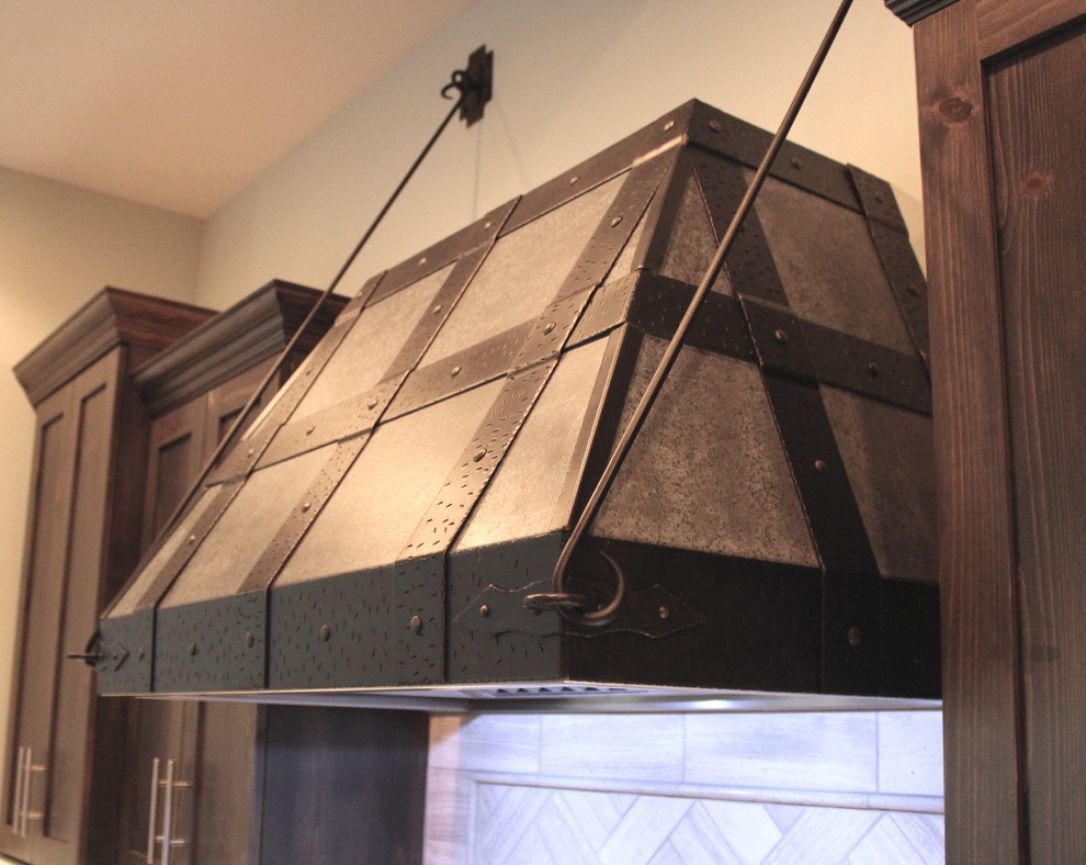 Eat-in kitchen - large rustic galley eat-in kitchen idea with recessed-panel cabinets, dark wood cabinets, beige backsplash and an island