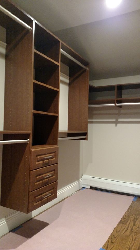 Design ideas for a large traditional walk-in wardrobe in Other with raised-panel cabinets, brown cabinets and medium hardwood floors.