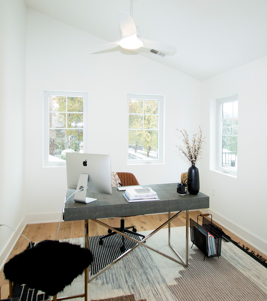 Photo of a mid-sized contemporary home office in DC Metro with white walls, light hardwood floors, no fireplace, a freestanding desk and beige floor.