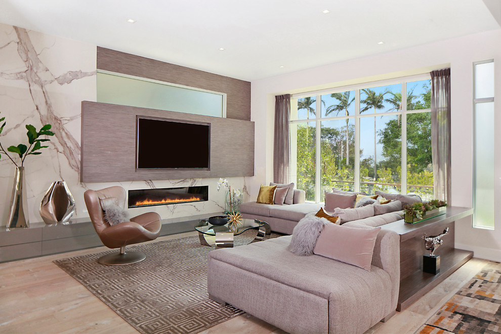 Photo of a large contemporary open concept living room in Los Angeles with white walls, light hardwood floors, a ribbon fireplace, beige floor, a stone fireplace surround and a wall-mounted tv.
