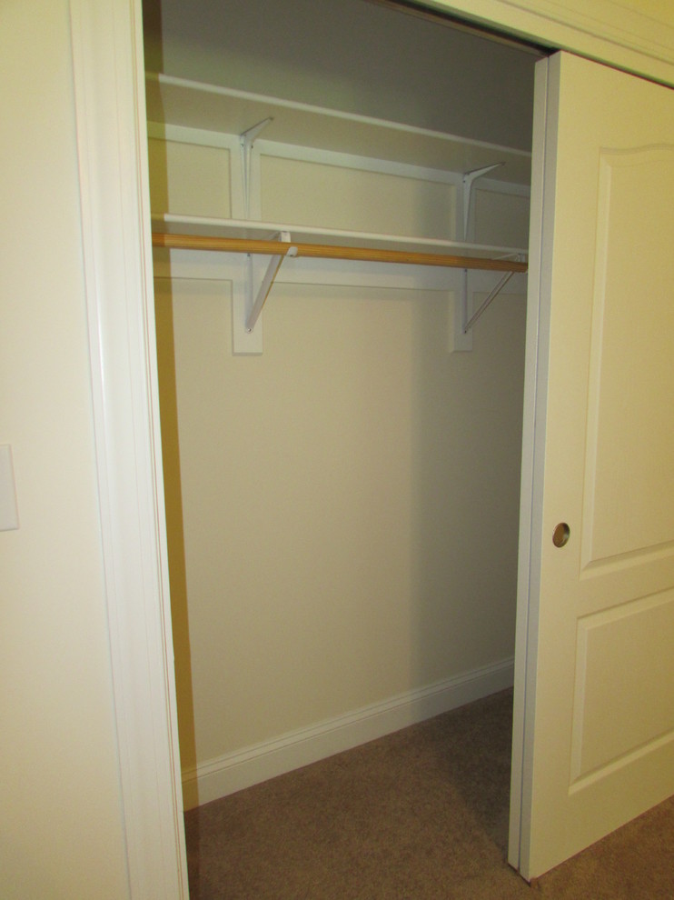 This is an example of a small traditional gender-neutral built-in wardrobe in Other with carpet.