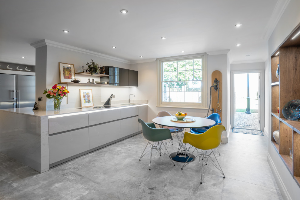 Large contemporary single-wall eat-in kitchen in Essex with an integrated sink, flat-panel cabinets, grey cabinets, quartzite benchtops, panelled appliances, ceramic floors, with island, grey floor and white benchtop.