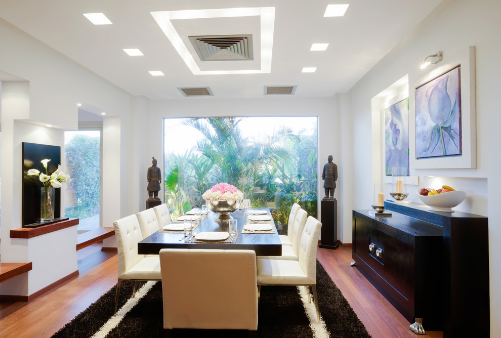 Contemporary dining room in Other with white walls and medium hardwood floors.